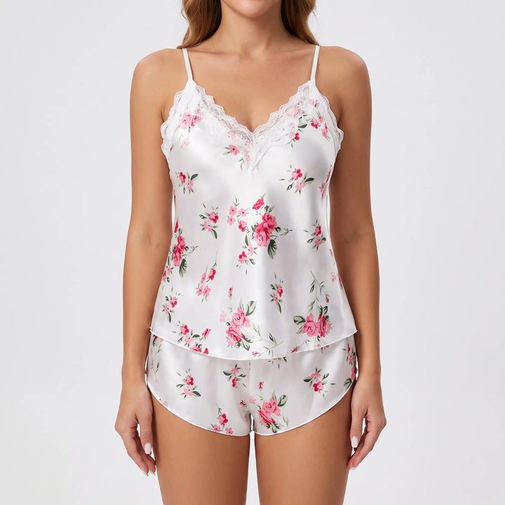 Front view on a model of the white satin pyjama set with pink roses and a lace-trimmed V-neck. 2
