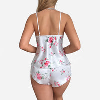 Back view of the set on a model, showing thin straps, the open back of the cami and rose print shorts. 3