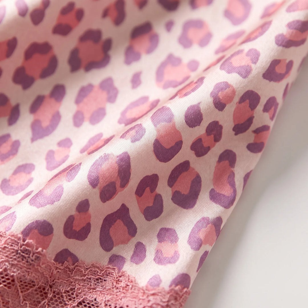Close-up of the pink and purple leopard-print satin fabric, showing its weave and a pink lace edge at the corner. 5