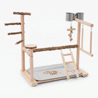 Wooden bird play stand on a plain white background, with natural branch perches, ladder, swing, two steel cups and a seed tray. 1