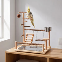 Wooden play stand on a sideboard by a window, with a yellow and grey cockatiel perched on the top branch. 2