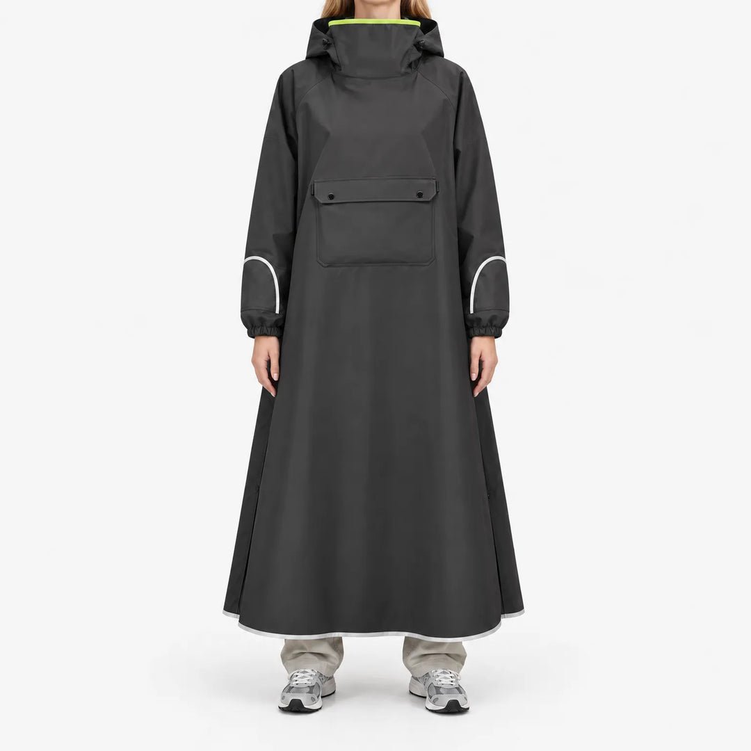 Front view of a model in the black version of the long poncho, with chest flap pocket, reflective sleeve and hem trim, and neon lime collar lining. 4