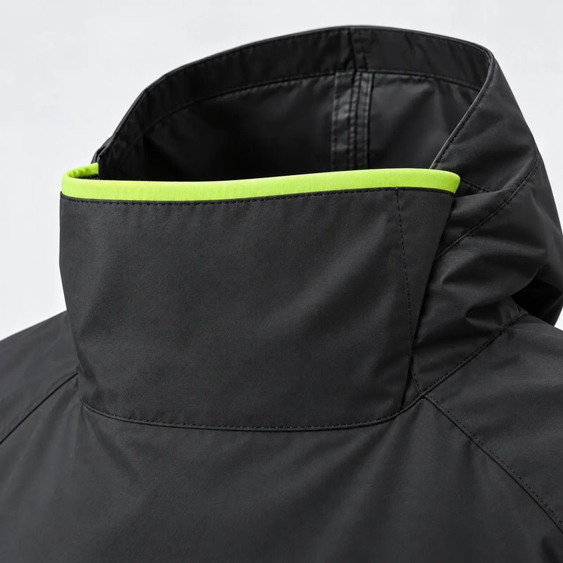 Close-up of the black poncho's high collar and hood, showing stitched seams and a bright lime green trim along the neck opening. 6