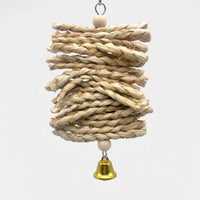 Hanging toy of stacked natural braided straw strands between two wooden beads, with a small gold bell at the bottom, on white. 1