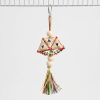 Whole woven toy hanging from a steel clip on a cage wire, with wooden beads, braided straw triangles and a colourful tassel. 1