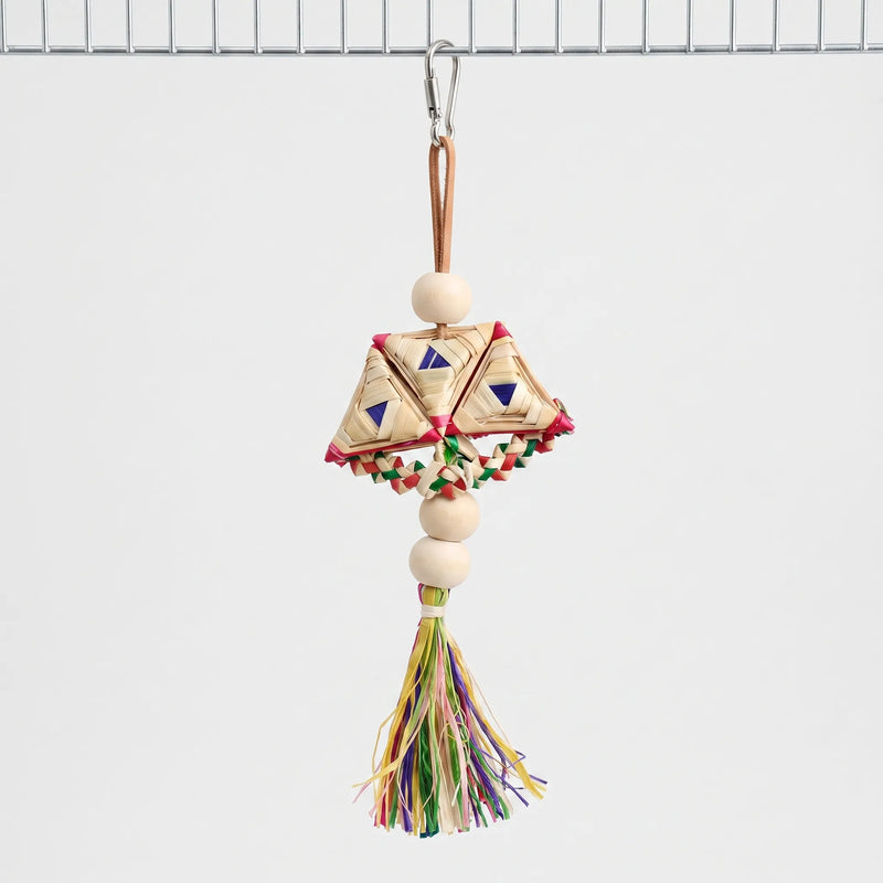 Whole woven toy hanging from a steel clip on a cage wire, with wooden beads, braided straw triangles and a colourful tassel. 1