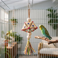 Toy hanging inside a wire cage beside a green and yellow budgerigar perched on a natural wooden branch. 2