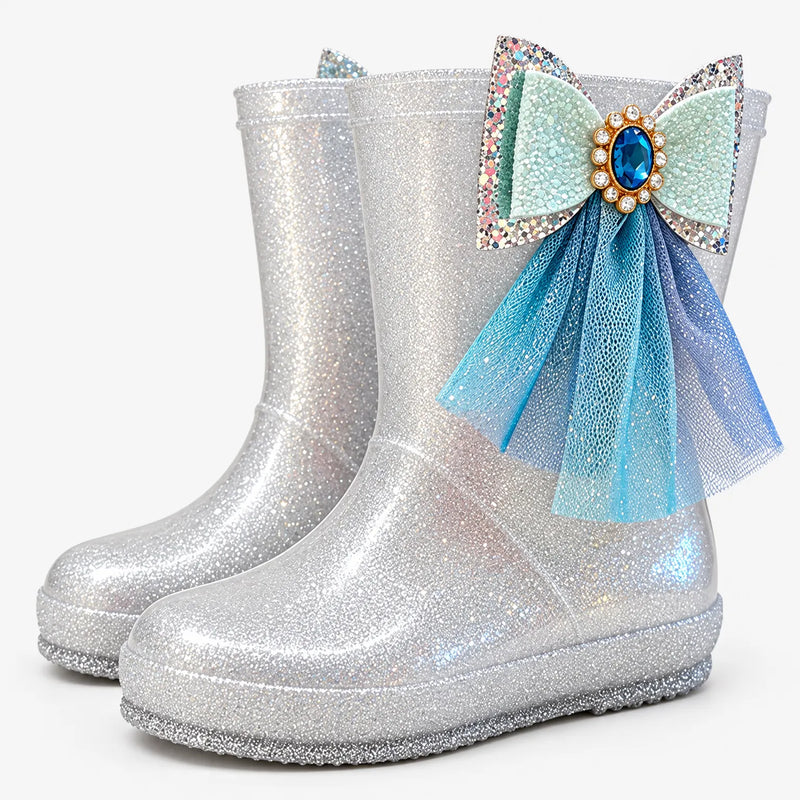 Pair of silver glitter boots at an angle, one with a jewelled mint bow and blue tulle streamers on the side. 7