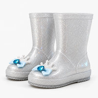 Pair of silver glitter rain boots at an angle, each toe decorated with a white crown, pale blue bow and blue gem. 8