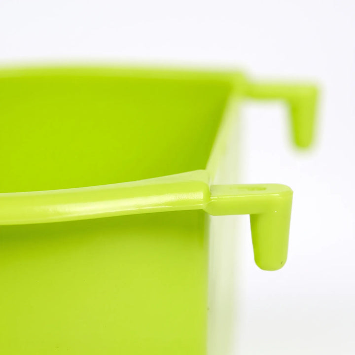 Close-up of a green bowl's rim and one of its hooks, showing the moulded plastic hanger up close. 3