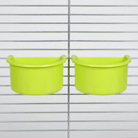 Two green half-round bowls hanging side by side on the metal bars of a cage, seen from the front. 4