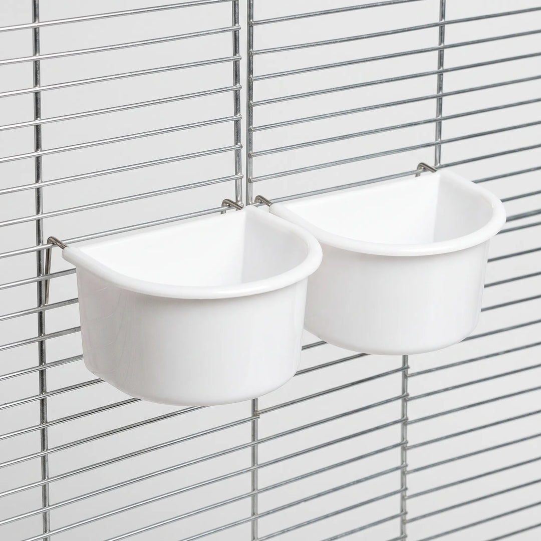 Two white bowls hanging on a metal cage grille, seen from an angle with thin metal hooks over the bars. 7