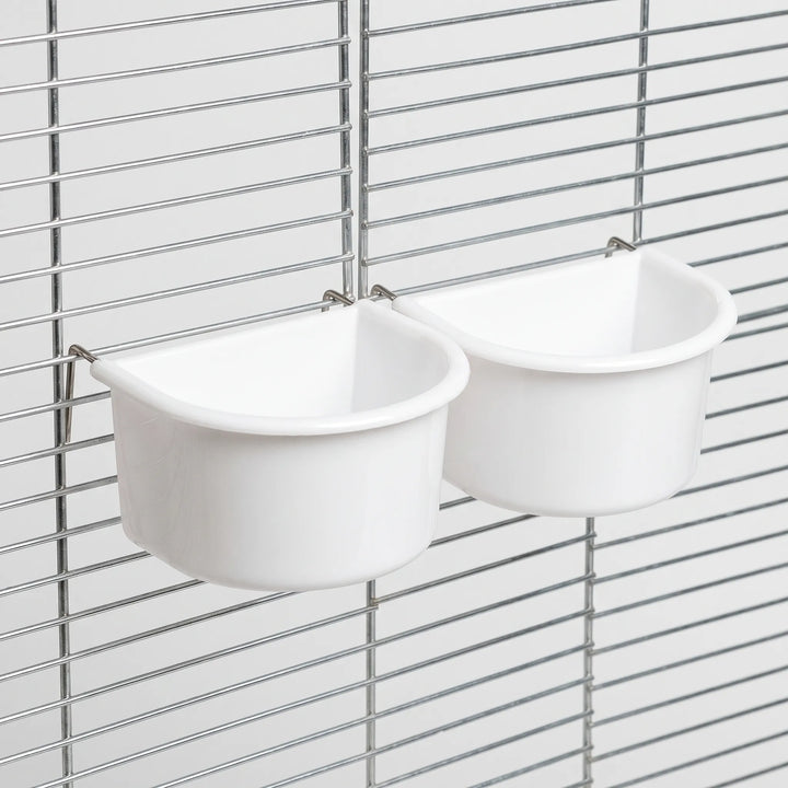 Two white bowls hanging on a metal cage grille, seen from an angle with thin metal hooks over the bars. 7