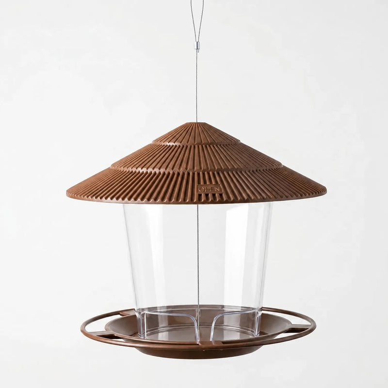 Brown version hanging empty on a steel wire, showing the ribbed roof, clear seed container and wide round feeding tray. 4
