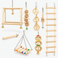 Set of wooden bird toys laid out on white: bead swings, ladder, rattan balls, loofah slices, straw rings, perch and bells. 1