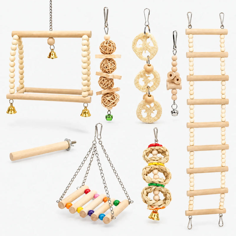 Set of wooden bird toys laid out on white: bead swings, ladder, rattan balls, loofah slices, straw rings, perch and bells. 1