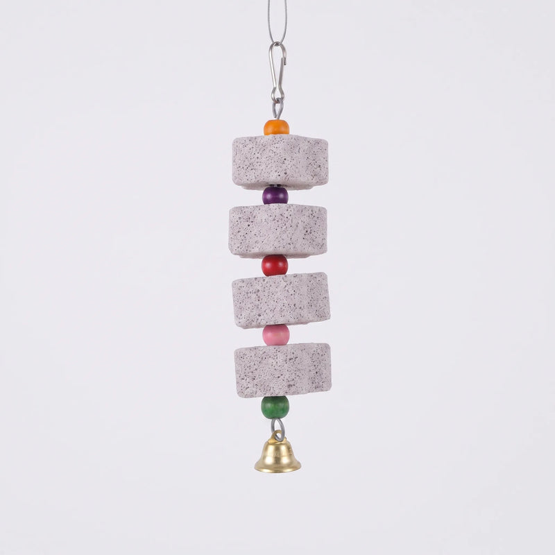 Four porous grey stone blocks strung with orange, purple, red, pink and green wooden beads, a clip above and a brass bell below, on plain background. 1