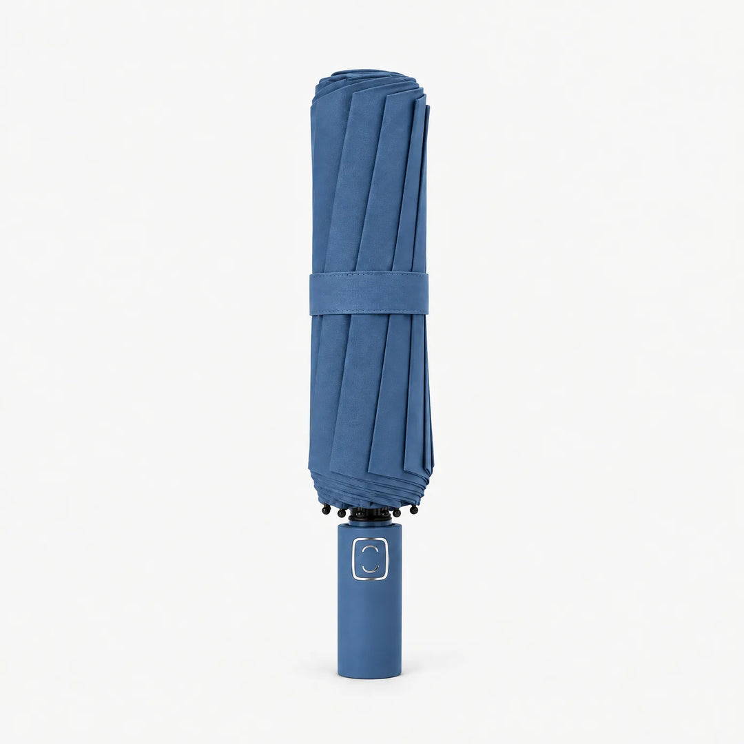 Folded denim blue umbrella standing upright on a white background, canopy secured by a fabric strap. 11