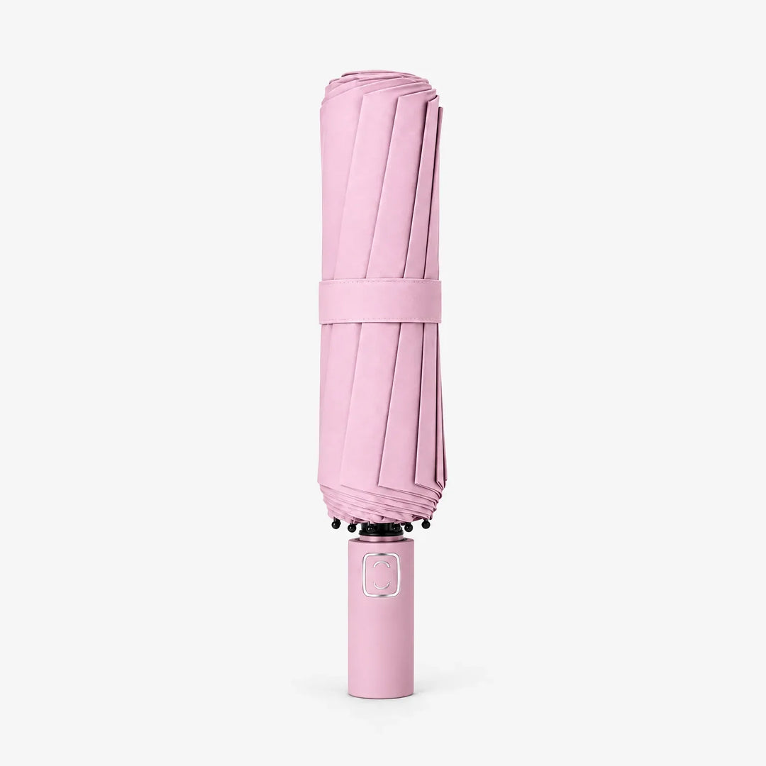 Folded pink umbrella with strap, standing upright on a white background with the handle at the bottom. 7
