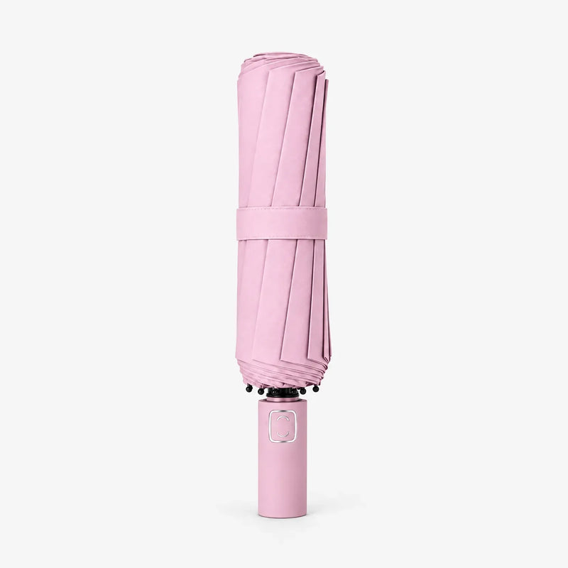 Folded pink umbrella with strap, standing upright on a white background with the handle at the bottom. 7