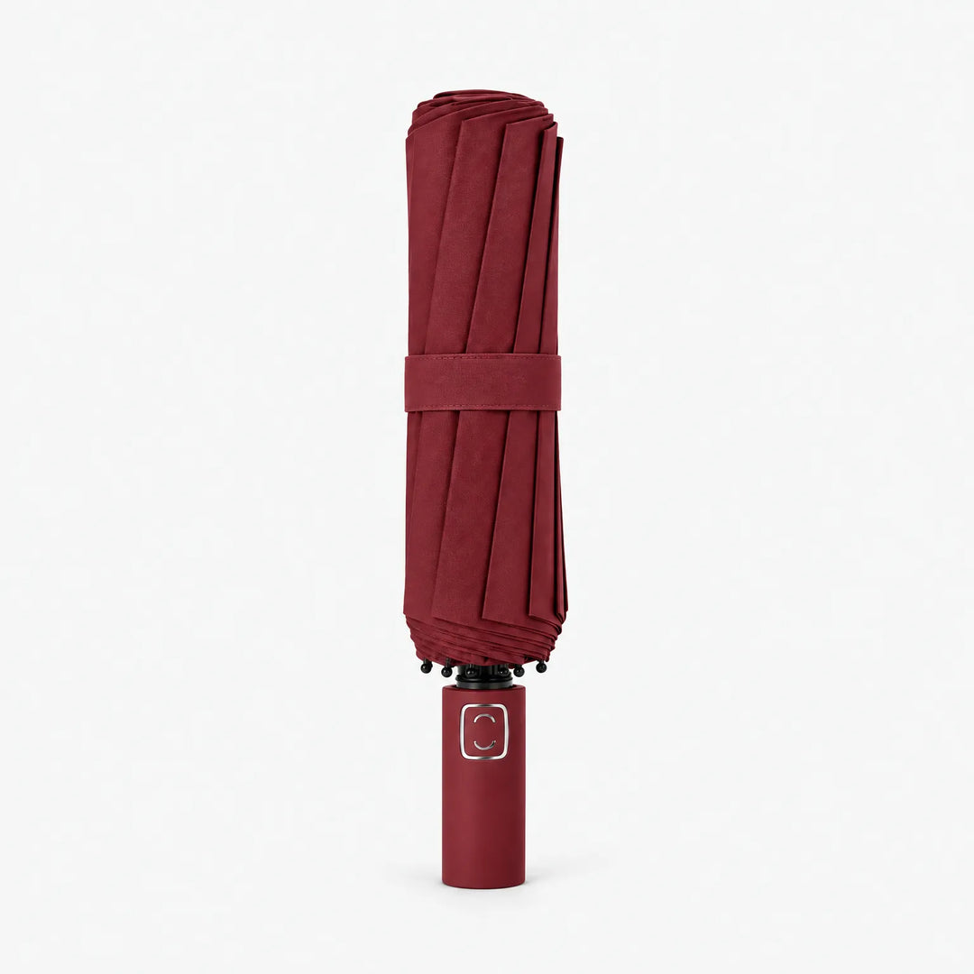 Folded dark burgundy umbrella standing upright on a white background, closed with a matching strap. 9
