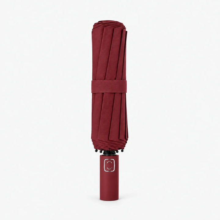 Folded dark burgundy umbrella standing upright on a white background, closed with a matching strap. 9