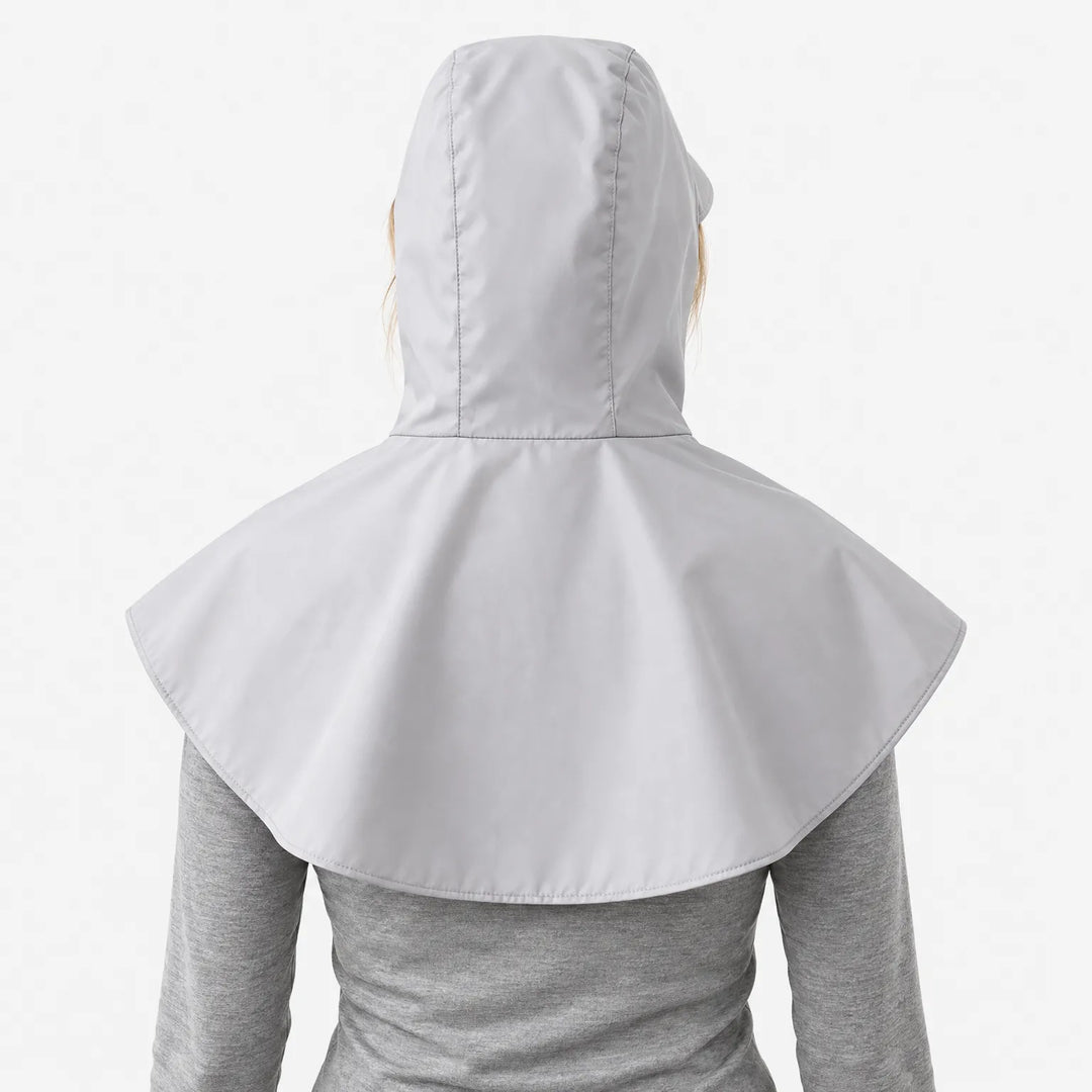 Back view of a light grey hooded cape with a wide rounded shoulder cover, worn over a grey long-sleeve top. 4
