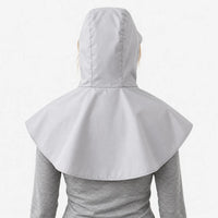 Back view of a light grey hooded cape with a wide rounded shoulder cover, worn over a grey long-sleeve top. 4