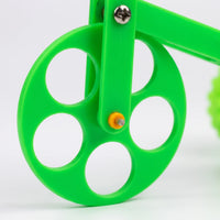 Close-up of the large front wheel with its round cut-outs, a metal screw and an orange axle cap. 3