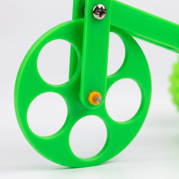 Close-up of the large front wheel with its round cut-outs, a metal screw and an orange axle cap. 3