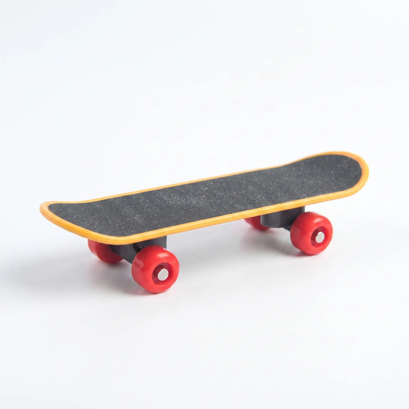 Miniature skateboard toy with a gritty black deck, orange edging and four red wheels, shown on a plain white background. 1