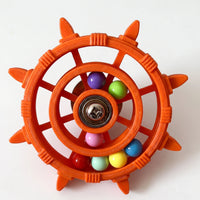 Orange version of the wheel toy with a visibly ridged plastic finish, a steel screw at the hub and seven coloured balls. 5