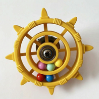 Yellow version of the wheel toy with a central bearing and six coloured balls gathered in the lower ring. 6