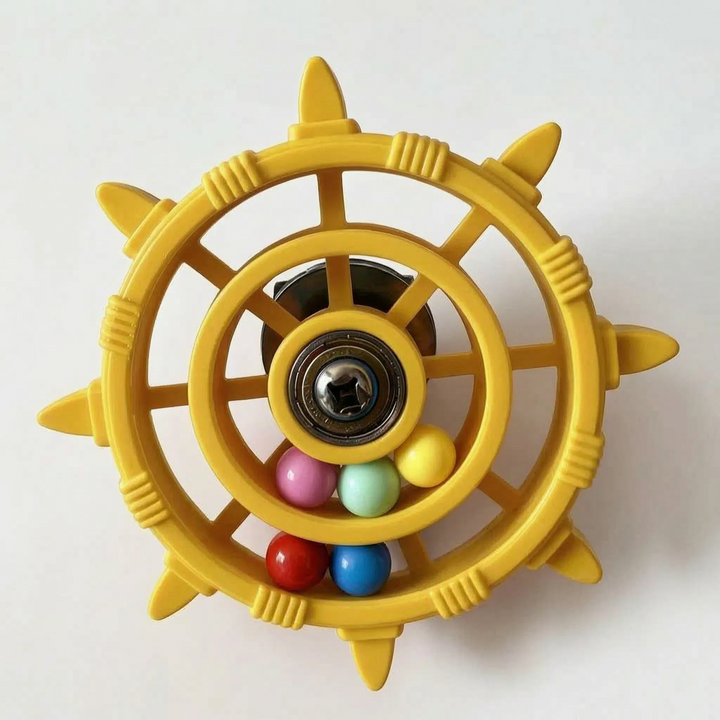 Yellow version of the wheel toy with a central bearing and six coloured balls gathered in the lower ring. 6