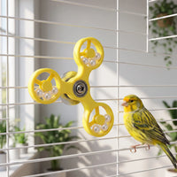 Yellow spinner toy on a white cage in a bright room, with a yellow-green canary perched beside it. 2