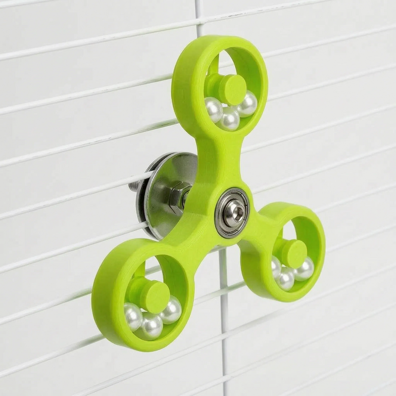 Lime green version of the spinner toy mounted on white cage bars, showing its metal fixing hardware at the back. 6