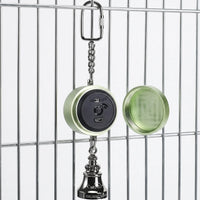 Green version hanging from cage bars with its screw-off cap removed beside it, revealing the black panel with switch, record button and charging port. 4