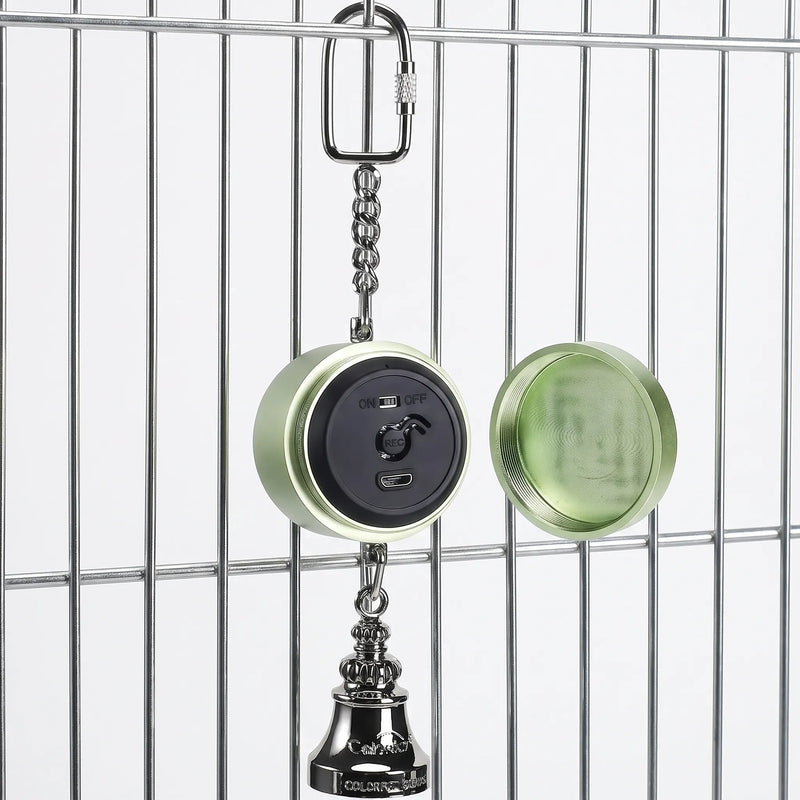 Green version hanging from cage bars with its screw-off cap removed beside it, revealing the black panel with switch, record button and charging port. 4