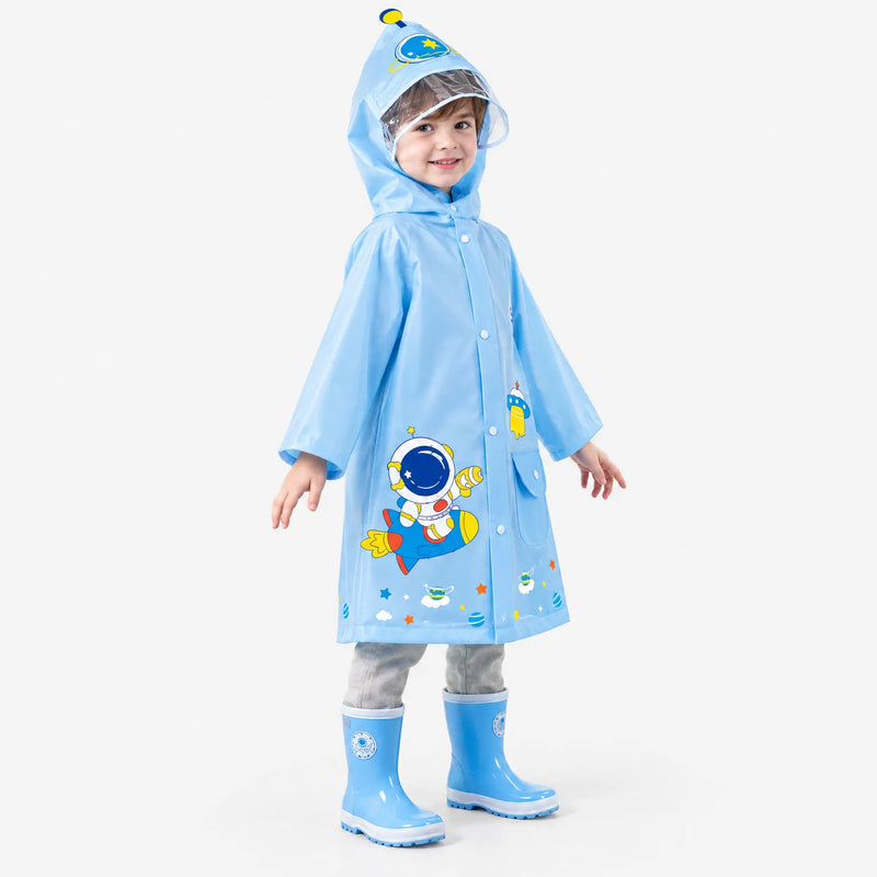 Boy in a light blue space raincoat with astronaut and rocket print, clear hood brim, and blue rain boots, turned slightly sideways. 5