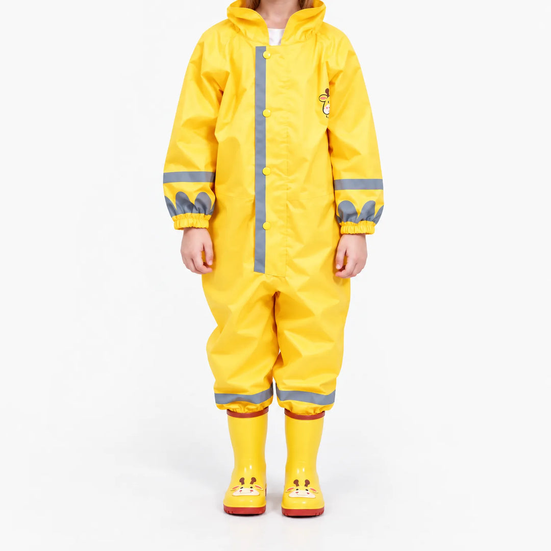 Front view of a child in the yellow hooded rain jumpsuit with grey reflective stripes, snap buttons, elastic cuffs and giraffe boots. 2