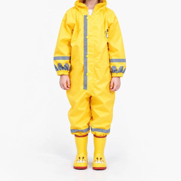 Front view of a child in the yellow hooded rain jumpsuit with grey reflective stripes, snap buttons, elastic cuffs and giraffe boots. 2
