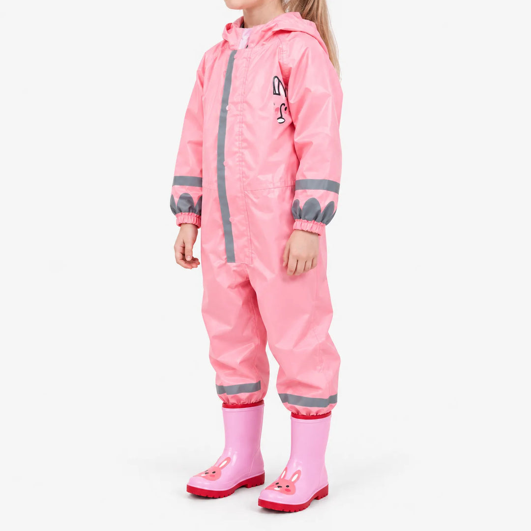 Side view of a girl in the pink rain jumpsuit with reflective stripes, elastic cuffs and pink bunny rain boots. 5