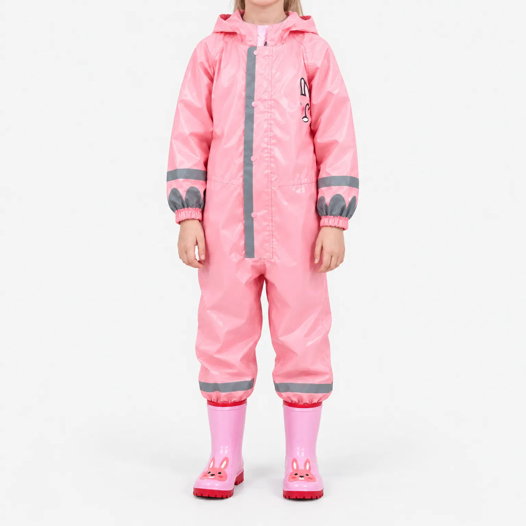 Front view of a girl in the glossy pink hooded rain jumpsuit with reflective stripes and pink bunny rain boots. 9