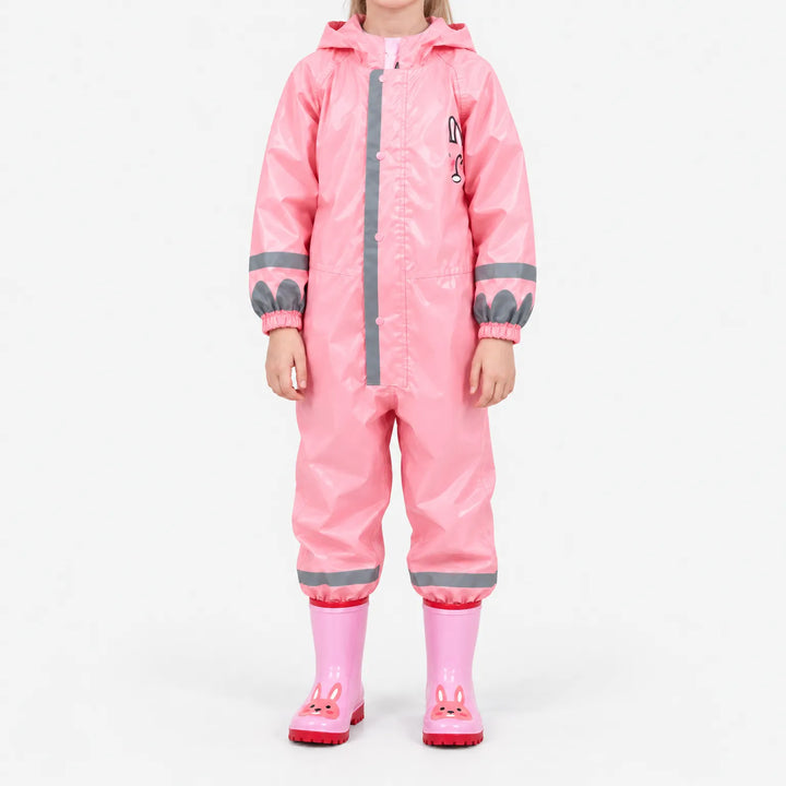 Front view of a girl in the glossy pink hooded rain jumpsuit with reflective stripes and pink bunny rain boots. 9