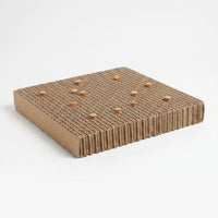 Corrugated cardboard platform with small cork stoppers pushed into its top, shown at an angle on a plain white background. 1