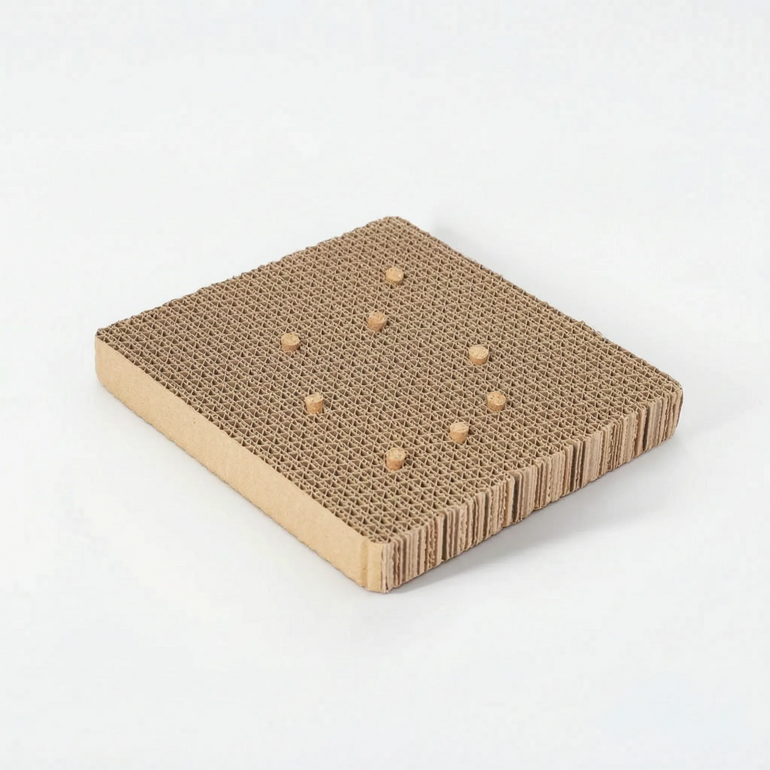Angled view of the cardboard platform with a smaller scattering of cork stoppers, showing the smooth cardboard side edge. 6