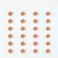 Flat lay of twenty-four spare cork stoppers arranged in a neat grid of rows on a white background. 9