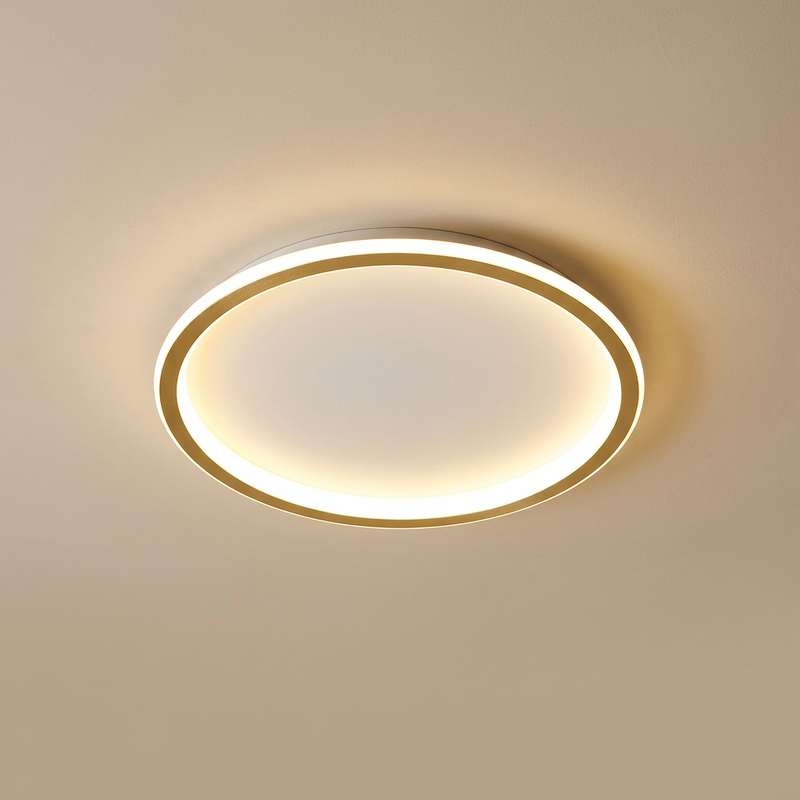 Round ceiling light with a white outer rim and a gold-coloured inner ring, glowing warmly 5