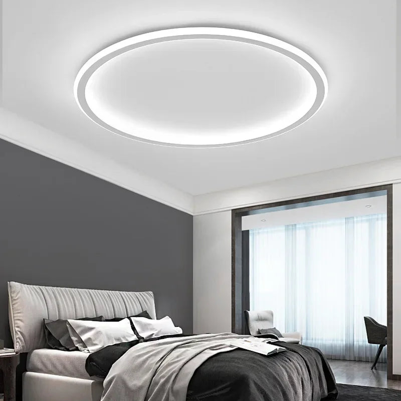 White round ceiling light shining cool white above a bed in a grey and white bedroom 5