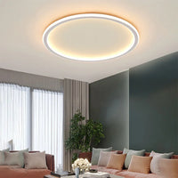 Round ceiling light with a white rim lit above a sofa with blush pink and grey cushions 3